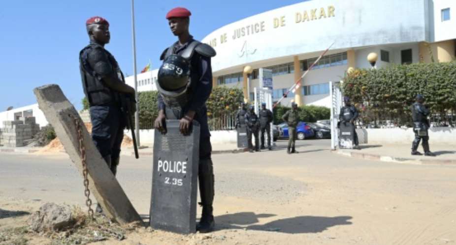 Police officers stand in front of Dakar courthouse during a court hearing of Senegalese opposition leader Ousmane Sonko over rape accusations.  By SEYLLOU AFP