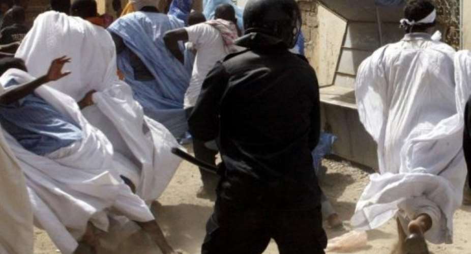A policeman tries to disrupt a protest march in Nouakchott.  By Georges Gobet (AFP/File)