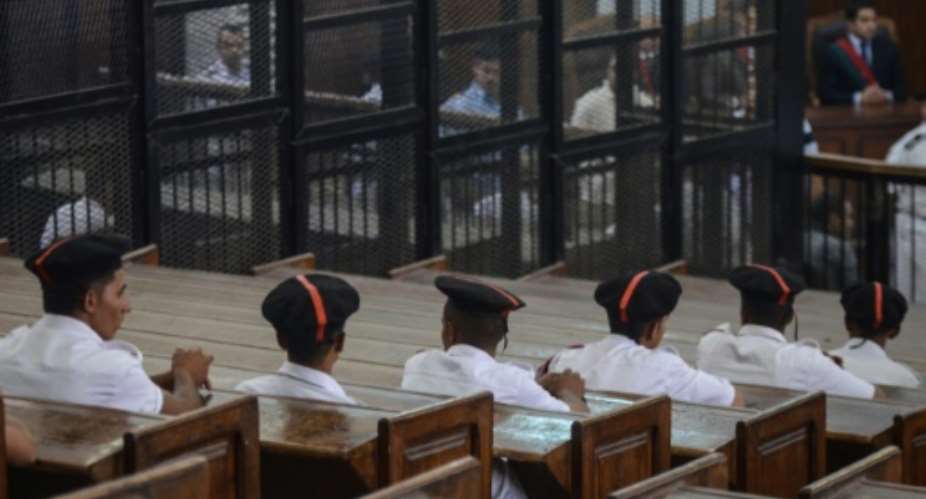 Policemen in court during the trial of 23 people charged over the September killing of police general Nabil Farrag in Kerdassa, considered to be a Muslim Brotherhood stronghold, in Cairo, on June 18, 2014.  By Mohamed El-Shahed AFPFile