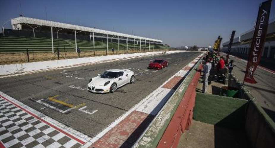 Fast cars take part in a test drive at the Kyalami race track in Johannesburg on July 23, 2014, a day before it went up for auction.  By Gianluigi Guercia AFPFile