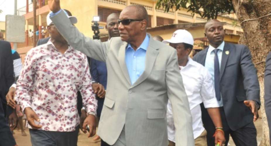 President Alpha Conde of Guinea waved after casting his vote outside a polling station in Conakry.  By CELLOU BINANI AFP