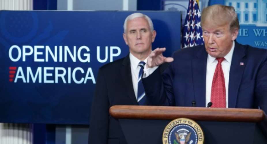 President Donald Trump, flanked by Vice President Mike Pence, announces a gradual reopening of the United States.  By MANDEL NGAN AFP