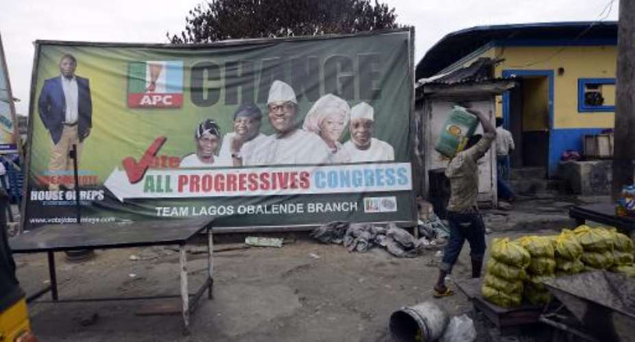 A man walks past a billboard of the main opposition All Progressives Congress APC presidential candidate Mohammadu Buhari in Lagos, on March 31, 2015.  By Pius Utomi Ekpei AFP