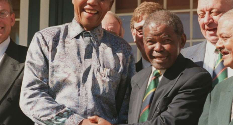 President Nelson Mandela L greets SA Rugby president Silas Nkanunu during a 1998 meeting in Cape Town.  By ANNA ZIEMINSKI AFP