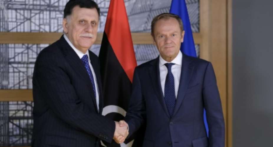 President of the European Council, Donald Tusk R welcomes Libyan Prime Minister Fayez al-Sarraj prior to a meeting in Brussels on May 13, 2019. Libyan strongman Khalifa Haftar's offensive against Tripoli represents a threat to international peace, the EU warned.  By OLIVIER HOSLET POOLAFP