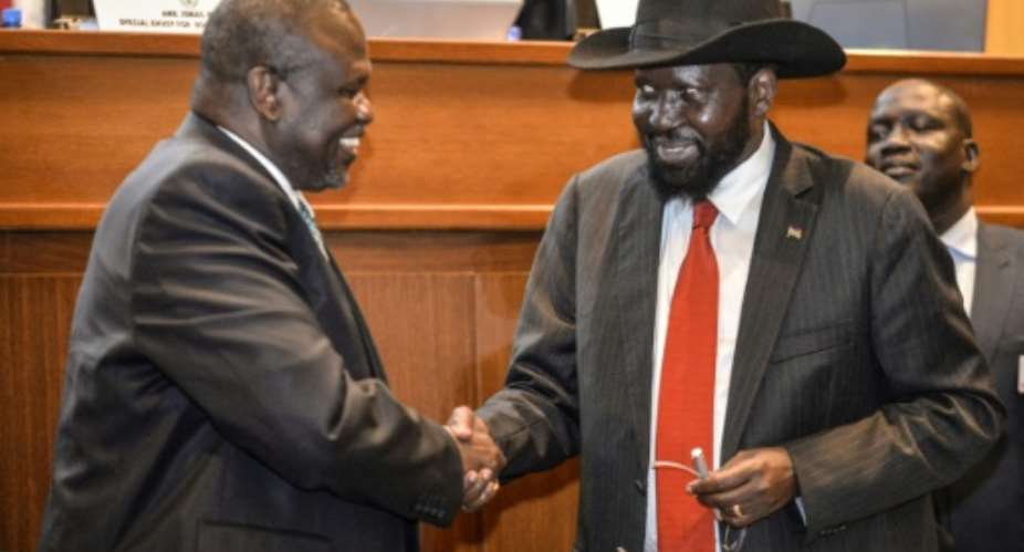 President Salva Kiir R and his estranged deputy  Riek Machar shake hands as they sign another peace deal.  By - AFPFile