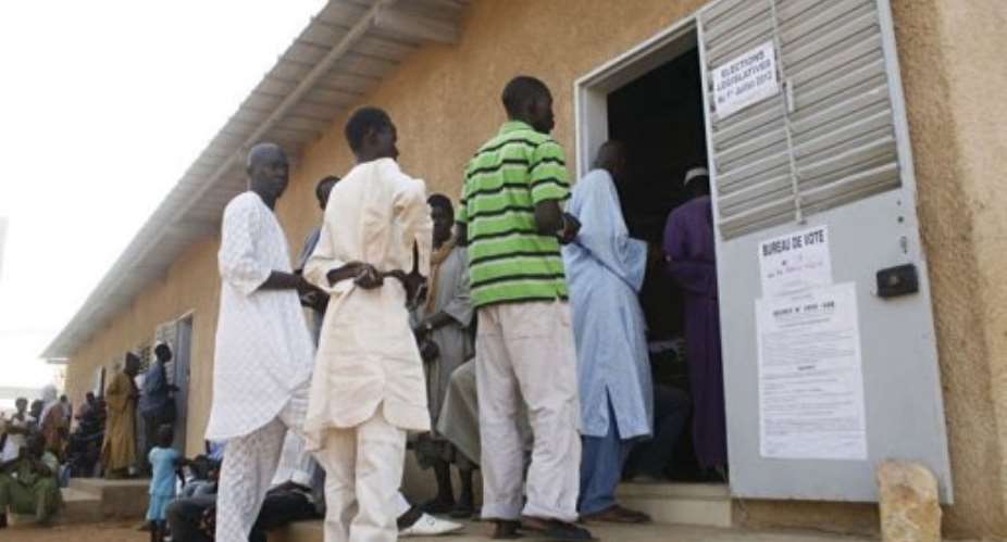 Men line up as they prepare to vote at a polling station in Dakar.  By Mamadou Toure Behan (AFP)