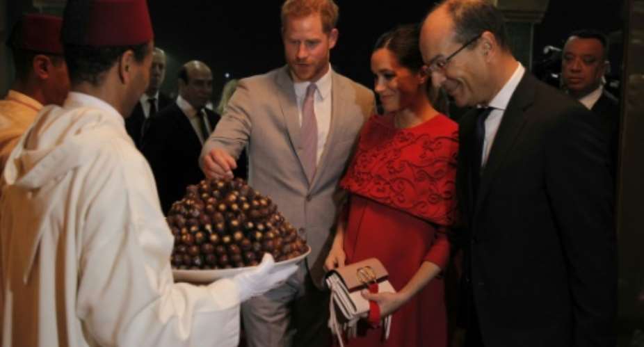 Prince Harry and Meghan were given a traditional welcome with a tray of dates on their arrival in Morocco.  By STR AFP