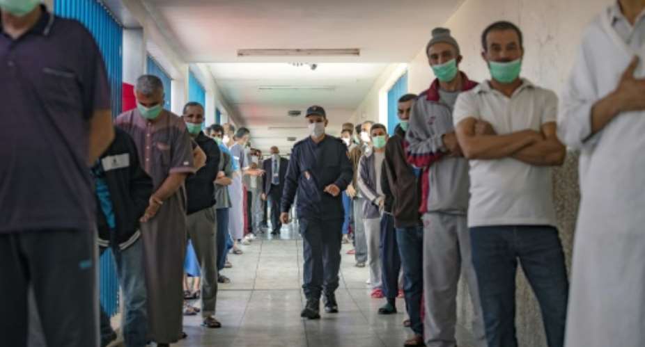 Prisoners wait their turn to receive a dose of the AstraZeneca coronavirus jab as part of a vaccination campaign at the El Arjat prison near the Moroccan capital Rabat.  By FADEL SENNA AFP