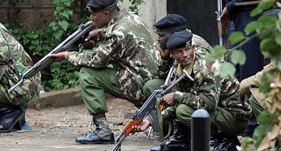 Armed Kenyan policemen take cover outside the Westgate mall in Nairobi on September 23, 2013.  By Simon Maina (AFP)
