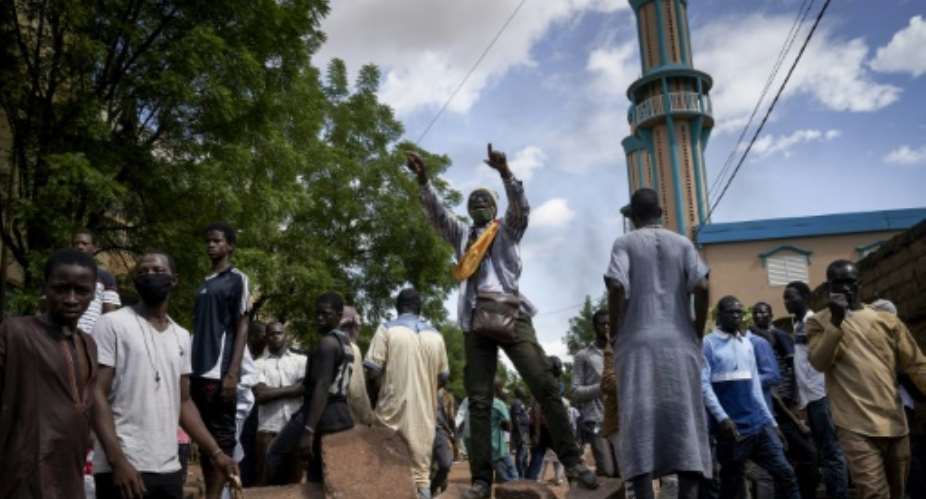 Protesters at a barricade erected in front of the Salam Mosque in Bamako, where Imam Mahmoud Dicko, a leader of the anti-government movement, led prayers on Sunday for victims of the clashes.  By MICHELE CATTANI AFP