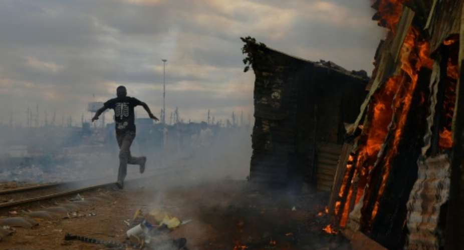Protesters burnt shacks to the ground in a Nairobi slum as violent demonstrations against Kenya's presidential election results flared for a second day.  By CARL DE SOUZA AFP