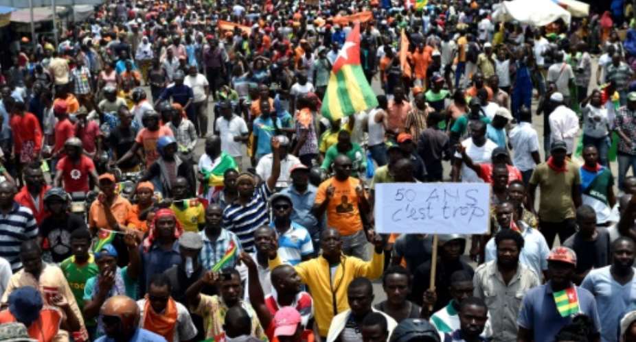 Protesters carry flags and placards while they march shouting slogans as they call for reforms during an anti-government rally in Lome on September 6, 2017.  By PIUS UTOMI EKPEI AFP