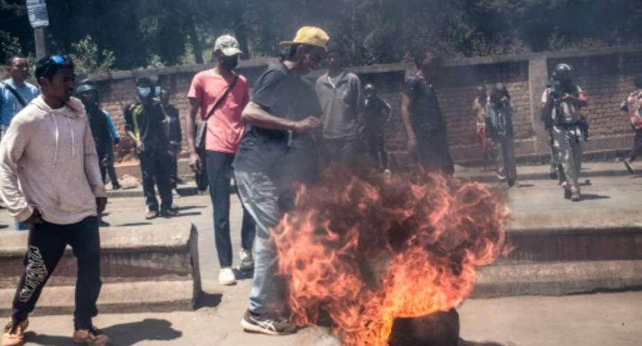 Protesters erect a burning barricade in Antananarivo as authorities respond with tear gas.  By RIJASOLO (AFP)