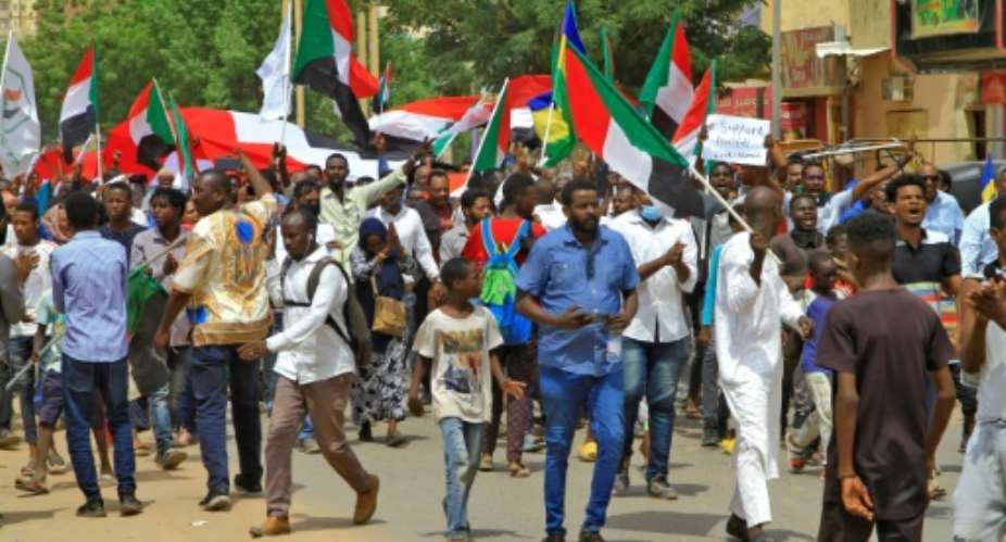 Protesters waving national flags march in an anti-coup demonstration in southern Khartoum on July 26, 2022.  By - (AFP)
