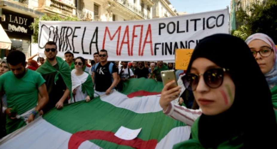 Protesting students hold a banner reading against the politico-financial mafia in Algiers on Tuesday.  By RYAD KRAMDI AFP