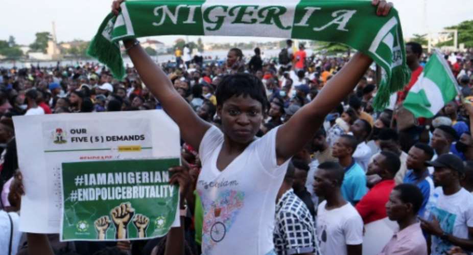 Protestors can be seen carrying Nigeria's green and white flag in what has become an ongoing festival of contestation.  By Pierre FAVENNEC AFP