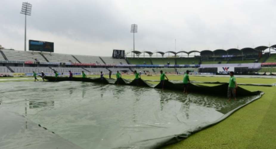 Ground staff remove the covers as they prepare the field for play during the fourth day of the second Test between Bangladesh and South Africa at Sher-e-Bangla National Cricket Stadium in Dhaka on August 2, 2015.  By Munir Uz Zaman AFP