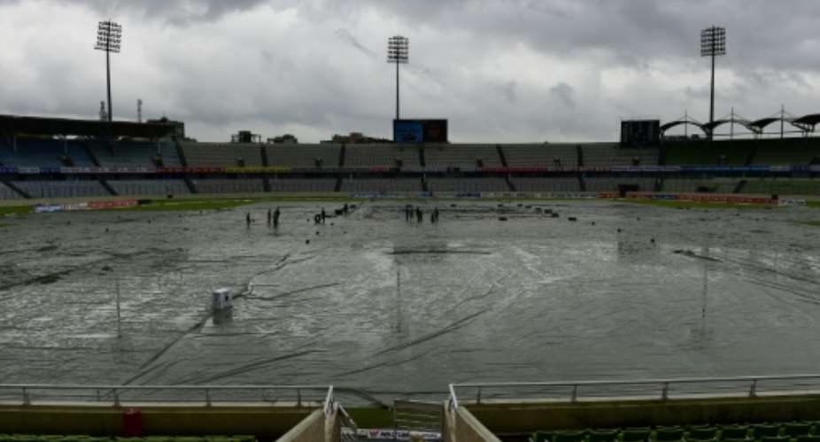 Workers on the field as rain delays the third day of the second Test between Bangladesh and South Africa at the Sher-e-Bangla National Cricket Stadium in Dhaka on August 1, 2015.  By Munir Uz Zaman AFP