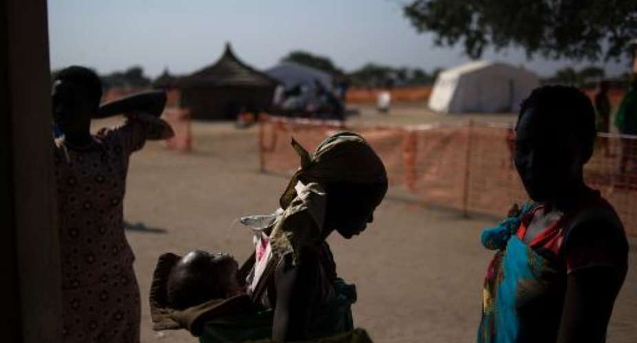 Internally displaced women stand outside a health centre set-up by the Doctors Without Borders charity in the village of Minkamen, South Sudan on January 11, 2014.  By Phil Moore AFPFile