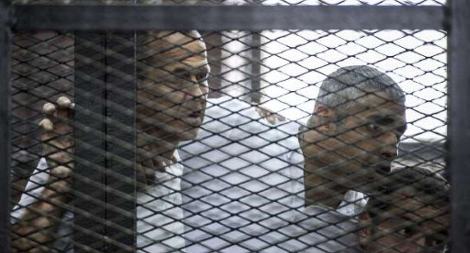 Al-Jazeera journalists Peter Greste L, Mohamed Fadel Fahmy C and Baher Mohamed, pictured during their trial for allegedly supporting the Muslim Brotherhood on June 23, 2014 in Cairo.  By Khaled Desouki AFPFile