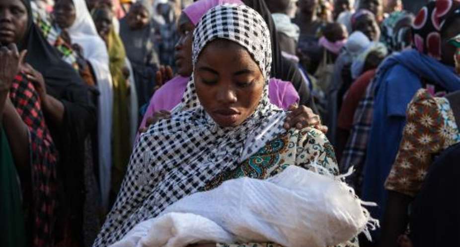 Women queue to receive humanitarian aid goods distributed by the Red Cross on December 3, 2014, in Yola, Nigeria, after fleeing Boko Haram attacks in their native regions.  By Florian Plaucher (AFP/File)