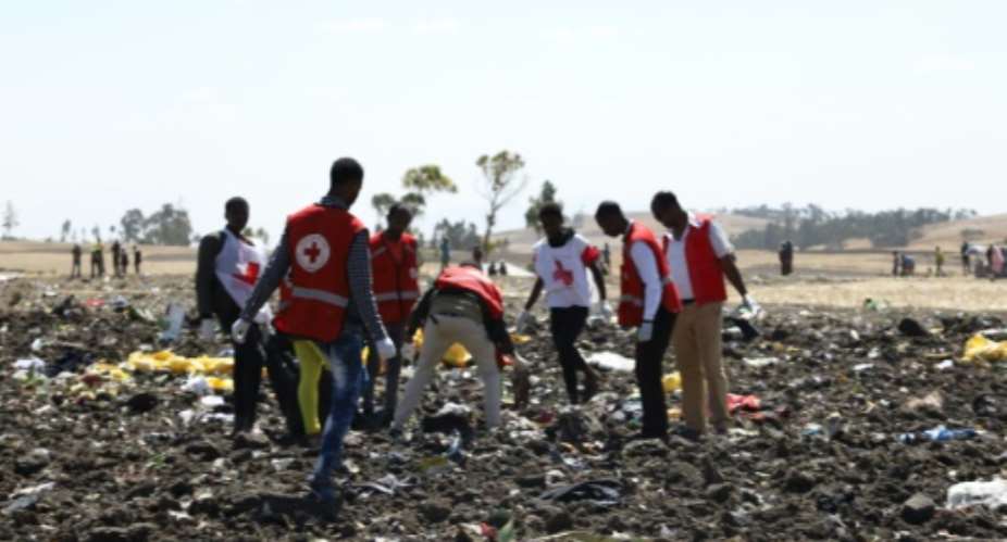 Red cross teams work through the debris after an Ethiopia Airlines flight to Nairobi crashed shortly after take-off from Addis Ababa, killing all 157 on board.  By Michael TEWELDE AFP