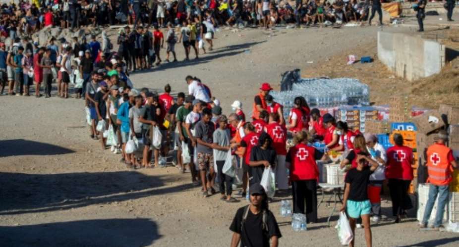 Red Cross volunteers distribute food to migrants who remain living on the streets of Ceuta.  By Antonio Sempere (AFP/File)