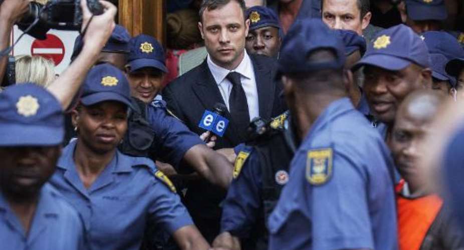 South African Paralympian athlete Oscar Pistorius C leaves the High Court in Pretoria on September 12, 2014 after the verdict in his murder trial.  By Gianluigi Guercia AFP
