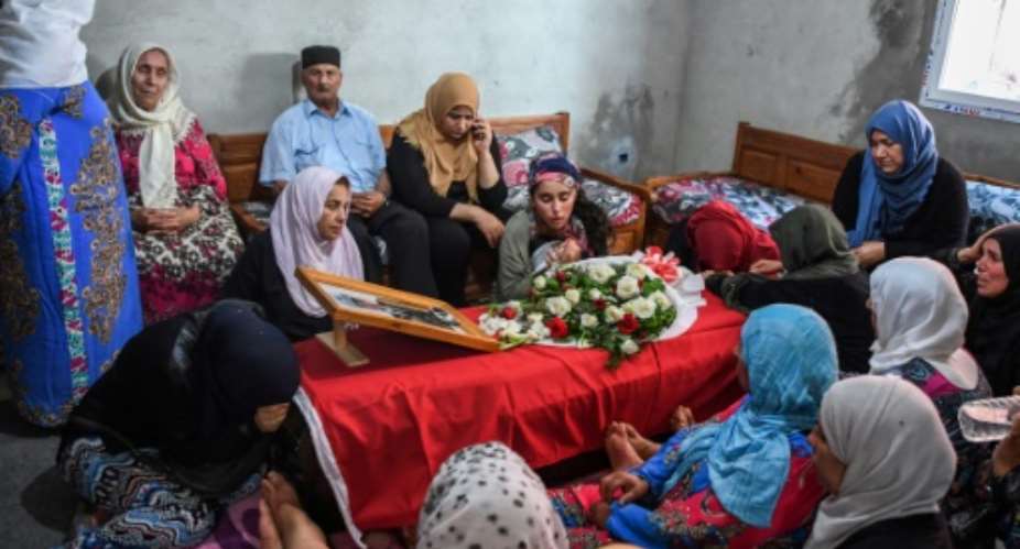 Relatives of Tunisian police officer Arbi Guizeni, killed in a jihadist attack Sunday, mourn over his coffin at their home in capital Tunis on July 9, 2018.  By FETHI BELAID AFP