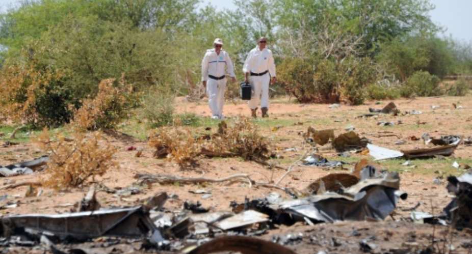 Forensic investigators gather evidence at the crash site of Air Algerie AH5017 in Mali's Gossi region, on July 29, 2014.  By Sia Kambou AFPFile