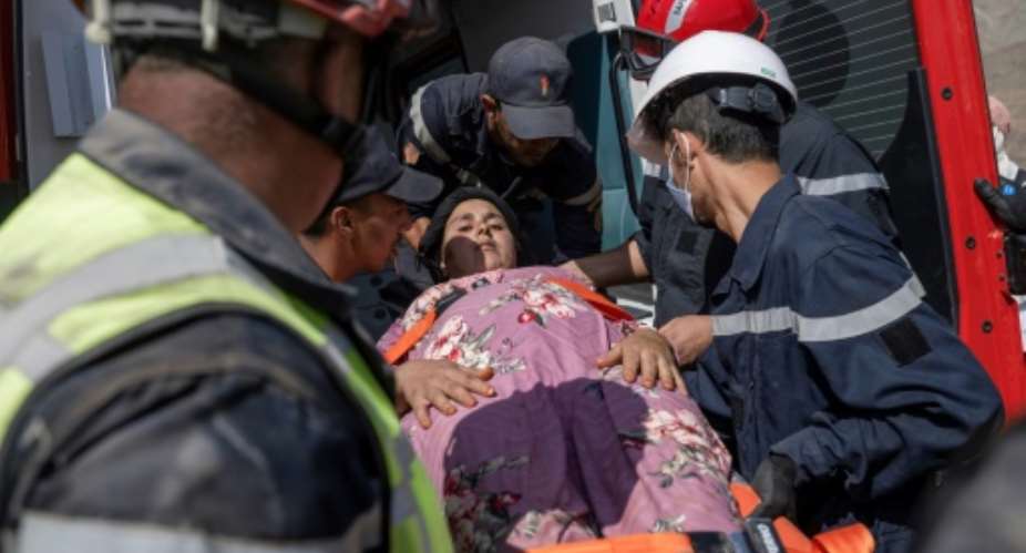Rescue workers evacuate a survivor of the Morocco quake after they rescued her from under the rubble.  By Bulent KILIC AFP