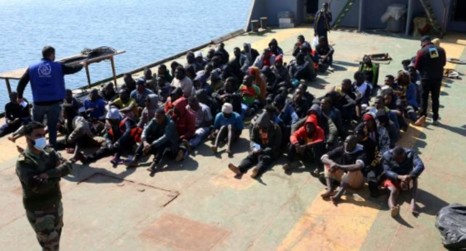 Rescued migrants sit aboard a Libyan coast guard vessel arriving at the capital Tripoli's naval base on February 28, 2021.  By Mahmud TURKIA AFPFile