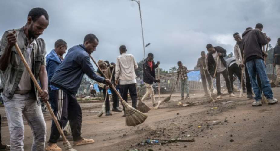 Resident volunteers clean the streets of Beshasha, hometown of Ethiopian Prime Minister Abiy Ahmed, who is expected to visit to vote.  By Marco Simoncelli (AFP/File)