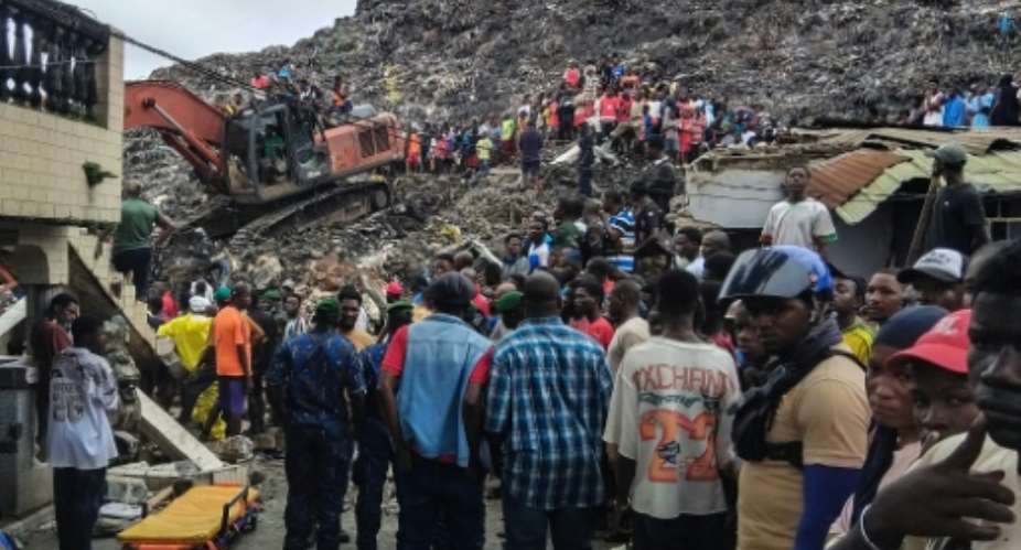 Residents and rescuers use an excavator to search for bodies after a landslide struck a dumpsite in Conakry, Guinea.  By - (AFP)
