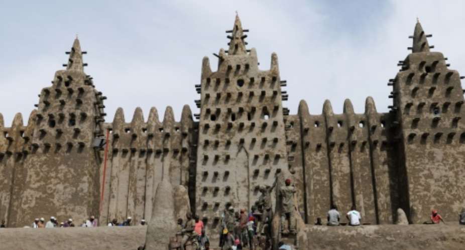 Residents apply traditional mud plaster to the Great Mosque of Djenne during the annual replastering ceremony.  By OUSMANE MAKAVELI (AFP)