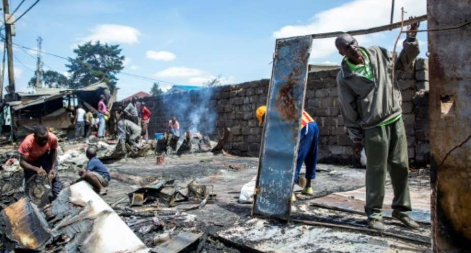 Residents of Nairobi's Kibera slum clean up a shop that was burned down during clashes after President Uhuru Kenyatta was declared the winner of last week's protest-hit election.  By PATRICK MEINHARDT AFP
