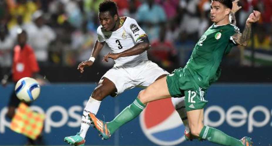 Ghana's forward Asamoah Gyan L kicks the ball to score a goal past Algeria's defender Carl Medjani during their 2015 African Cup of Nations group C football match in Mongomo on January 23, 2015.  By Carl De Souza AFP