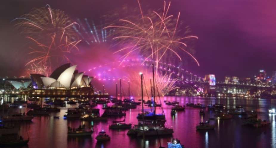 Revellers camped out at vantage points, taking in the early family-friendly fireworks display over the Sydney Harbour Bridge.  By PETER PARKS (AFP)