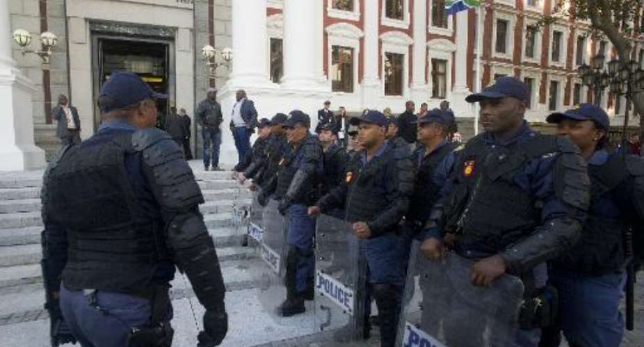South African riot policemen line up outside the parliament following a scuffle in the general assembly in Cape Town on August 21, 2014.  By Rodger Bosch AFP