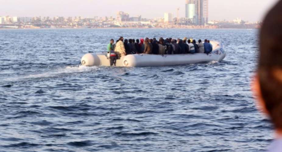 Libyan coastguards carry rescued migrants on a dinghy off Tripoli on October 5, 2015.  By Mahmud Turkia AFP