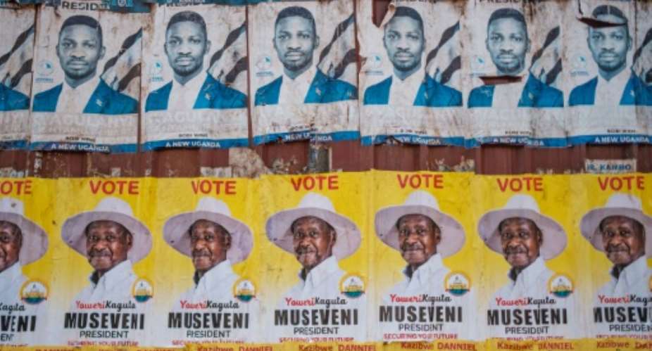 Rivals: Election campaign posters for Bobi Wine, in blue, and Yoweri Museveni, in yellow.  By SUMY SADURNI AFP