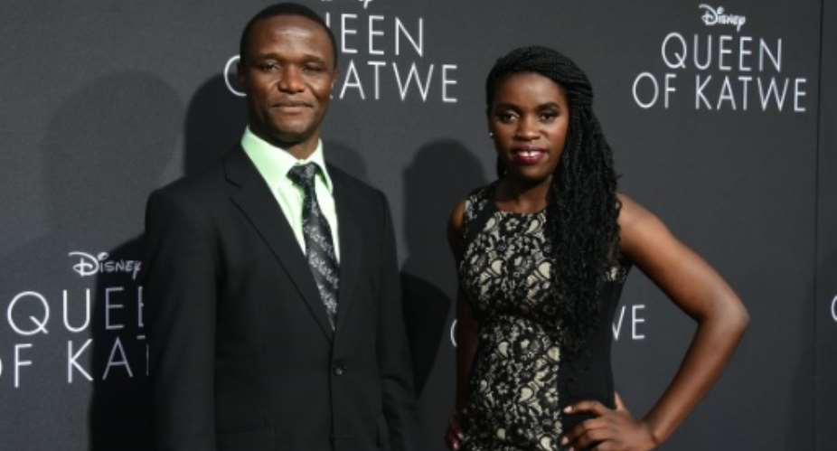 Robert Katende and Phiona Mutesi R, whose life on which the story is based, pose on arrival for the premiere of Disney's Queen of Katwe in Hollywood, California on September 20, 2016.  By Frederic J Brown AFPFile