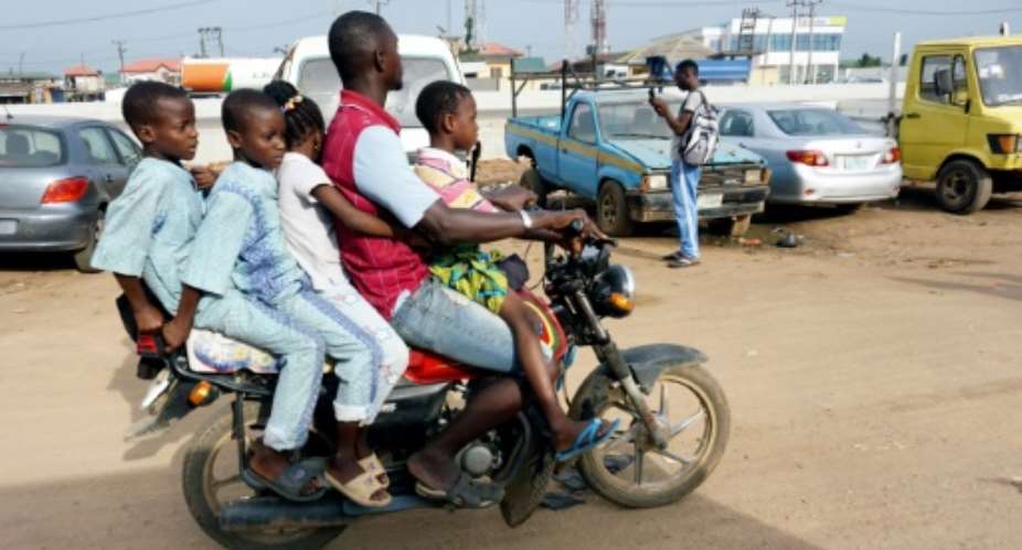 Room for one more? A traditional motorcycle taxi on Lagos roads -- overladen and not a crash helmet in sight.  By PIUS UTOMI EKPEI AFP