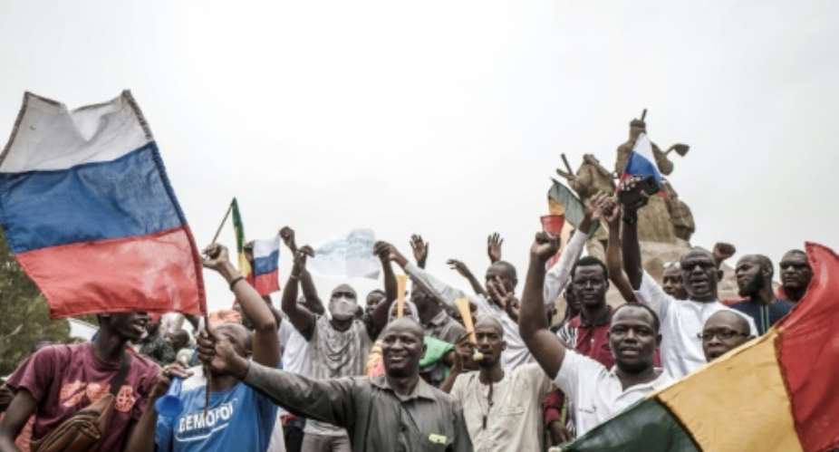 Russian and Malian flags are waved by protesters in Bamako, during a demonstration against French influence in the country on May 27, 2021.  By Michele Cattani AFP