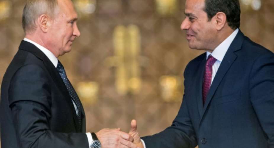 Russian President Vladimir Putin L shakes hands with Egyptian counterpart Abdel Fattah al-Sisi after giving a press conference following their talks at the presidential palace in the capital Cairo on December 11, 2017.  By Alexander ZEMLIANICHENKO POOLAFP