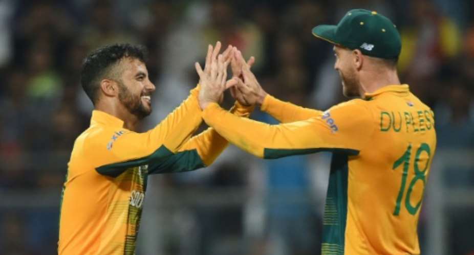 South Africa's JP Duminy and captain Faf du Plessis celebrate the wicket of England's captain Eoin Morgan during their World T20 match in Mumbai on March 18, 2016.  By Indranil Mukherjee AFP