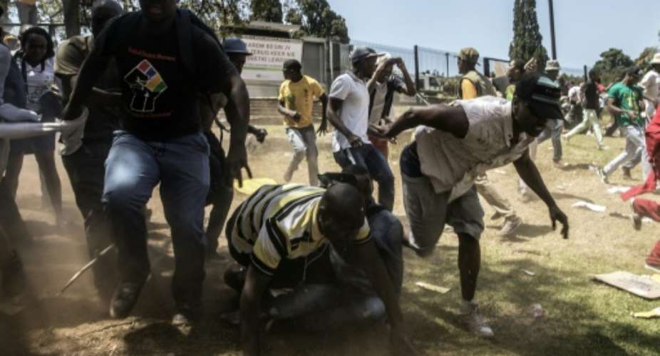 Students run away from stun grenades and tear gas during a protest against hikes to university fees, outside the government headquarters on October 23, 2015 in Pretoria.  By Gianluigi Guercia AFPFile