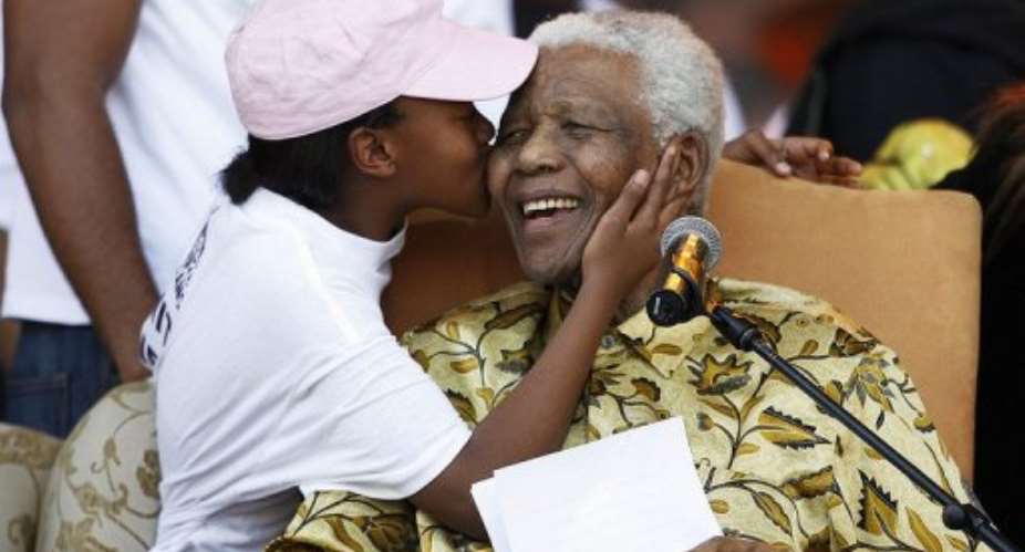 Nelson Mandela receives a kiss from one of his grandchildren in 2008. He is to spend his 94th birthday with his family.  By Gianluigi Guercia AFPFile