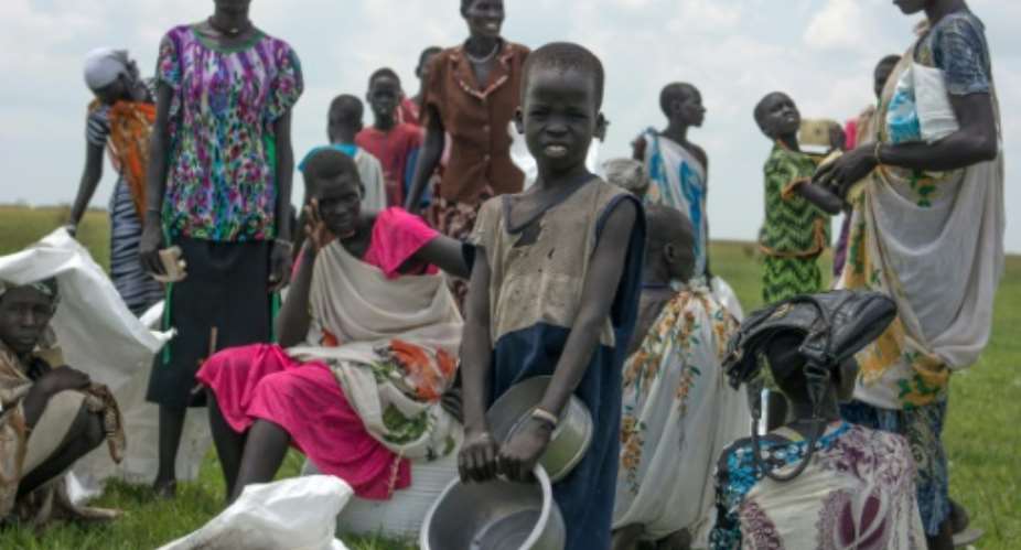 Internally displaced women and children wait for food rations after a humanitarian airdrop by the World Food Programme WFP in South Sudan's Unity State on July 25, 2015.  By Charles Lomodong AFPFile